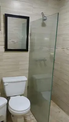 a bathroom with a toilet and a glass shower at Dominican Suite 2, Increíble apto. cama king (DS2) in San Felipe de Puerto Plata