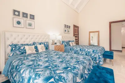 a blue and white bedroom with two beds at Beautiful 2 BR apartment at Portillo in Las Terrenas