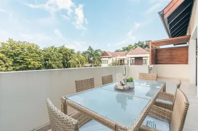 a patio with a table and chairs on a balcony at Beautiful 2 BR apartment at Portillo in Las Terrenas