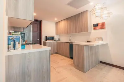 a kitchen with wooden cabinets and a counter top at Beautiful 2 BR apartment at Portillo in Las Terrenas