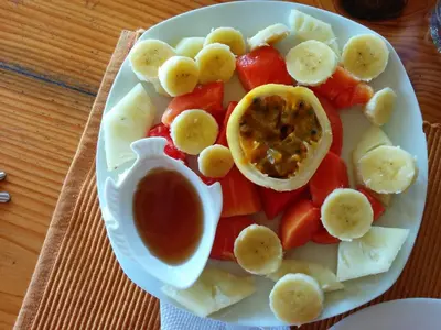 a plate of fruit and vegetables with a dipping sauce at B&B Aparthotel La Isleta in Las Galeras