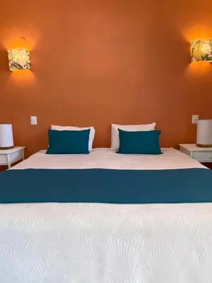 a bedroom with a large bed with blue pillows at Hotel Casa Coson in Las Terrenas