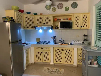 a kitchen with yellow cabinets and a stainless steel refrigerator at Excelente apartamento en Las Terrenas, Playa Punta Popi. in Las Terrenas