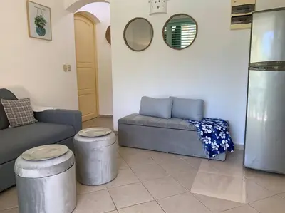 a living room with a couch and two stools at Excelente apartamento en Las Terrenas, Playa Punta Popi. in Las Terrenas