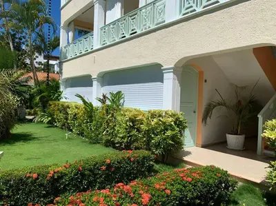 a house with a garage and some bushes and flowers at Excelente apartamento en Las Terrenas, Playa Punta Popi. in Las Terrenas