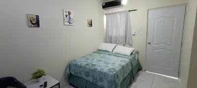 a small bedroom with a bed and a door at HEA Stays in San Felipe de Puerto Plata