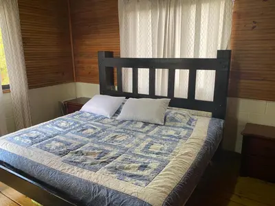 a bedroom with a bed with a blue and white quilt at VILLA LOMAS LINDAS in La Montosa