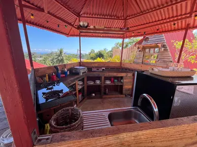 an outdoor kitchen with a sink and a stove at Tinyhouse samaná