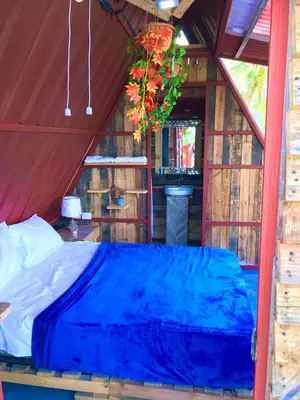 a bed in a tent with a blue sheet at Tinyhouse samaná