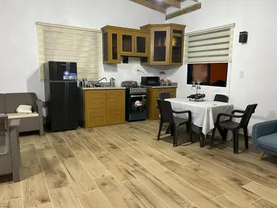 a kitchen and dining room with a table and a kitchen and a table and chairs at Villa vista al rio in Jarabacoa