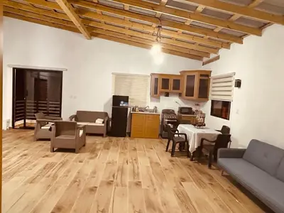 a living room with a table and chairs and a kitchen at Villa vista al rio in Jarabacoa