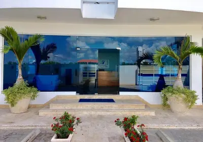a room with two palm trees and a building at Elegant Blue Sky View Lux at Juan Dolio Las Velas in Juan Pedro