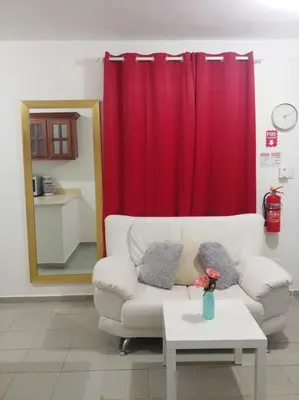 a living room with a couch and a red curtain at Dominican Suite 21, Amazing Apt/Studio (DS21) in San Felipe de Puerto Plata