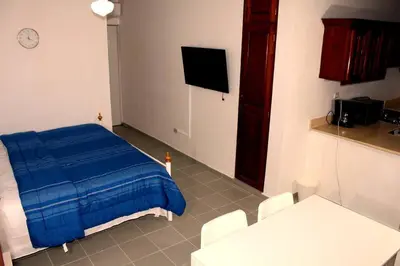 a room with a bed and a tv in it at Dominican Suite 11, Amazing Apt/Studio (DS11) in San Felipe de Puerto Plata