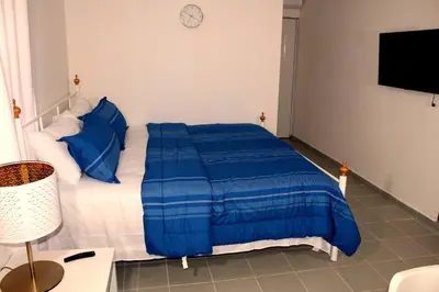 a bed with a blue comforter in a room at Dominican Suite 11, Amazing Apt/Studio (DS11) in San Felipe de Puerto Plata