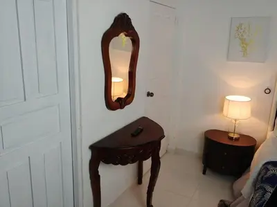 a bathroom with a table and a mirror on the wall at Dominican Suite 1, Incredible Suite/Studio (DS1) in San Felipe de Puerto Plata