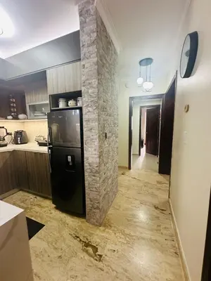 a kitchen with a black refrigerator and a stone wall at Luxury apto 3 rooms+pool+ campo de golf. Cocotal in Punta Cana