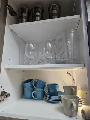 a shelf with glasses and cups and plates at Luxury apto 3 rooms+pool+ campo de golf. Cocotal in Punta Cana