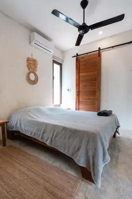 a bedroom with a large bed with a ceiling fan at El Valle Villas in Santa Bárbara de Samaná