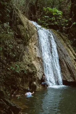 a group of people in the water near a waterfall at El Valle Villas in Santa Bárbara de Samaná