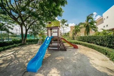 a playground with a blue slide and a tower at Apartment Almas Iberosta Bavaro 3BDR with Pool & Private Beach in Punta Cana