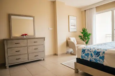 a bedroom with a bed and a dresser with a mirror at Apartment Almas Iberosta Bavaro 3BDR with Pool & Private Beach in Punta Cana
