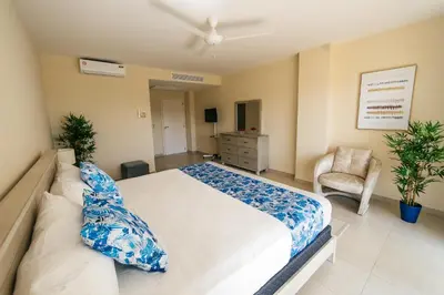 a bedroom with a large bed and a chair at Apartment Almas Iberosta Bavaro 3BDR with Pool & Private Beach in Punta Cana
