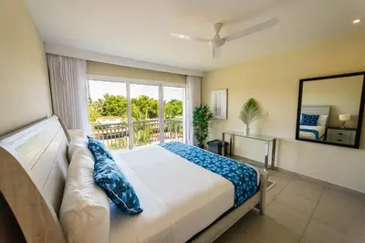 a bedroom with a bed and a large window at Apartment Almas Iberosta Bavaro 3BDR with Pool & Private Beach in Punta Cana