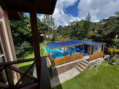 a house with a blue roof with a pool at Hacienda Claro de Luna 3 Bedrooms in Jarabacoa
