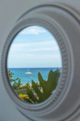 a view of the ocean from a beach through a mirror at Fortunity Club- Playa Dorada, Pto Plata in Sampiño