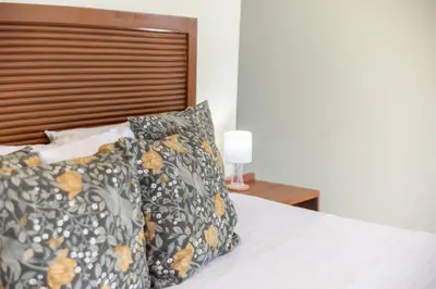 a bed with two pillows and a wooden headboard at Hotel La Casona MC in La Romana