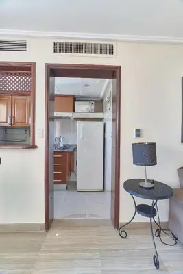 a kitchen with a table and a refrigerator at VIP Exclusive One Bedroom Apartment in Santo Domingo