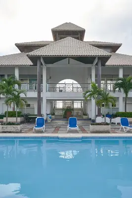 a resort with a swimming pool and blue chairs at VIP Exclusive One Bedroom Apartment in Santo Domingo