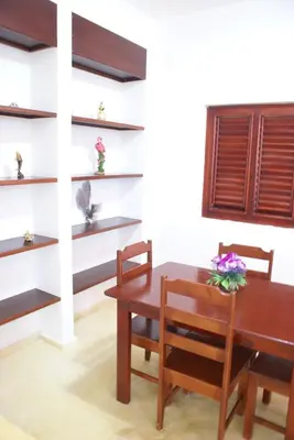 a dining room with a table and chairs and shelves at Villa del Mar in Punta Balandra