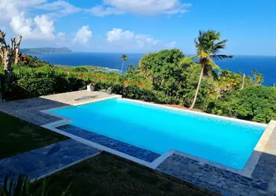 a swimming pool with the ocean in the background at Villa del Mar in Punta Balandra