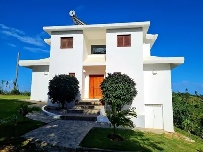 a white house with a orange door at Villa del Mar in Punta Balandra