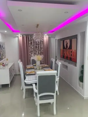 a dining room with a table and chairs and purple lights at Luxury apartment with Pool in Santiago de los Caballeros