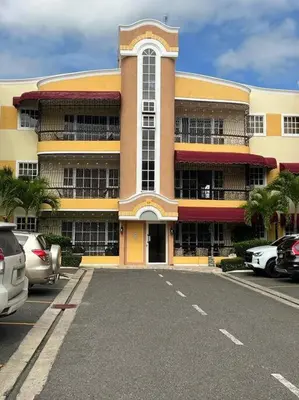 a large building with cars parked in a parking lot at Luxury apartment with Pool in Santiago de los Caballeros