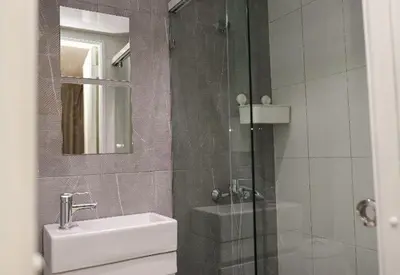 a bathroom with a shower and a sink and a mirror at Residencial Frank I in Santo Domingo