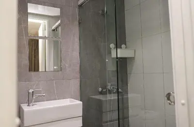 a bathroom with a shower and a sink and a mirror at Residencial Frank I in Santo Domingo