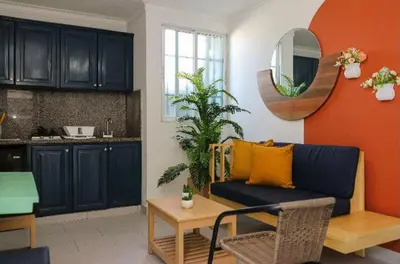 a living room with a blue couch and an orange wall at Residencial Frank I in Santo Domingo