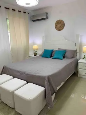 a bedroom with a large bed with blue pillows at Juan Dolio apart1 hab in Juan Pedro