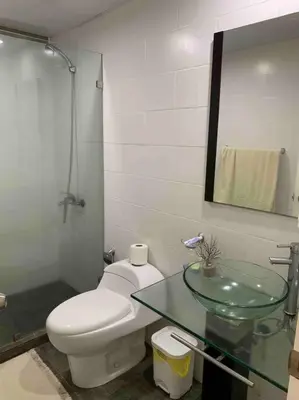 a bathroom with a toilet and a glass sink at Juan Dolio apart1 hab in Juan Pedro