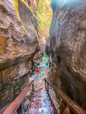a group of people standing in a river in a canyon at Peninsula Esmeralda Luxury Hotel & Villas in San Felipe de Puerto Plata