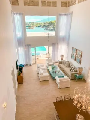 a large living room with white furniture and a large window at Peninsula Esmeralda Luxury Hotel & Villas in San Felipe de Puerto Plata