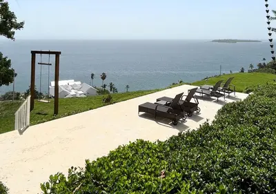 a group of chairs sitting next to the ocean at Lovely house with private beach in Santa Bárbara de Samaná