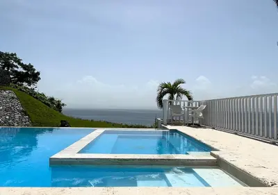a swimming pool with a chair next to a fence at Lovely house with private beach in Santa Bárbara de Samaná