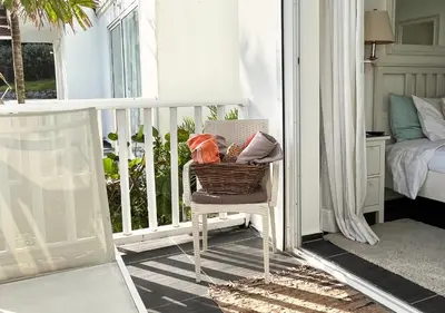 a balcony with a chair and a bed and a window at Lovely house with private beach in Santa Bárbara de Samaná