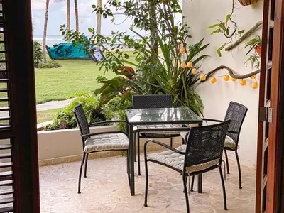 a glass table and chairs on a patio at CABARETE BEACH HOUSES the NANNY ESTATES in Cabarete