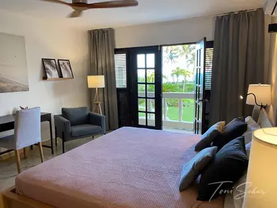a bedroom with a bed and a desk and a window at CABARETE BEACH HOUSES the NANNY ESTATES in Cabarete